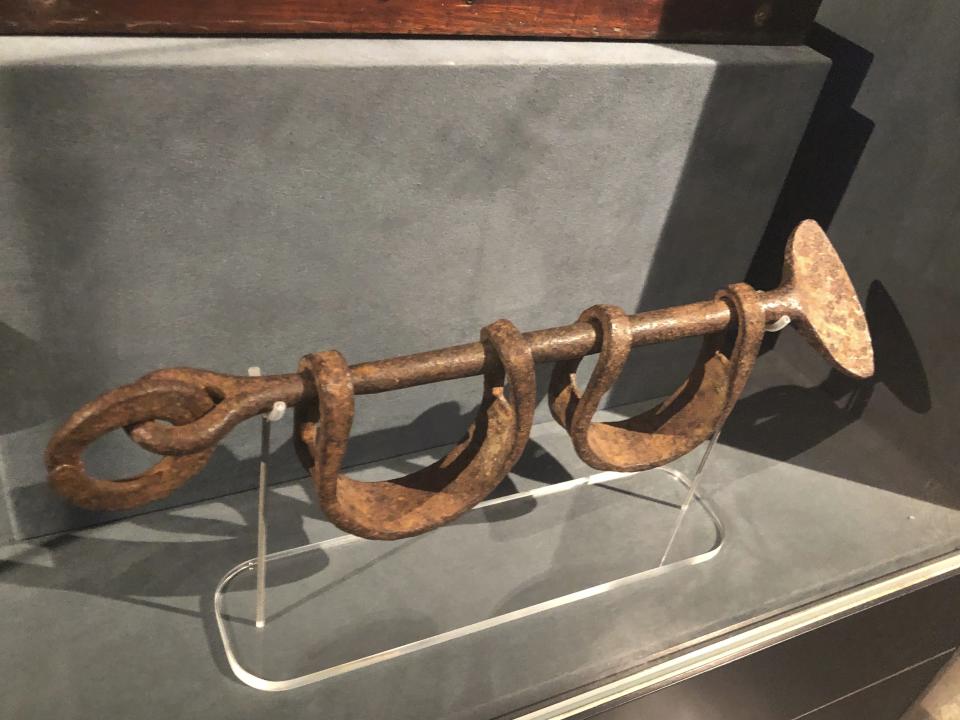 In this Nov. 24, 2019 photo, a set of 18th Century leg iron shackles that once held black slaves sits on display at the International Slavery Museum in Liverpool, England. The museum through artifacts from slavery and black history seeks to tell the story of the enslavement of people from Africa and how the British city benefited from human bondage. (AP Photo/Russell Contreras)