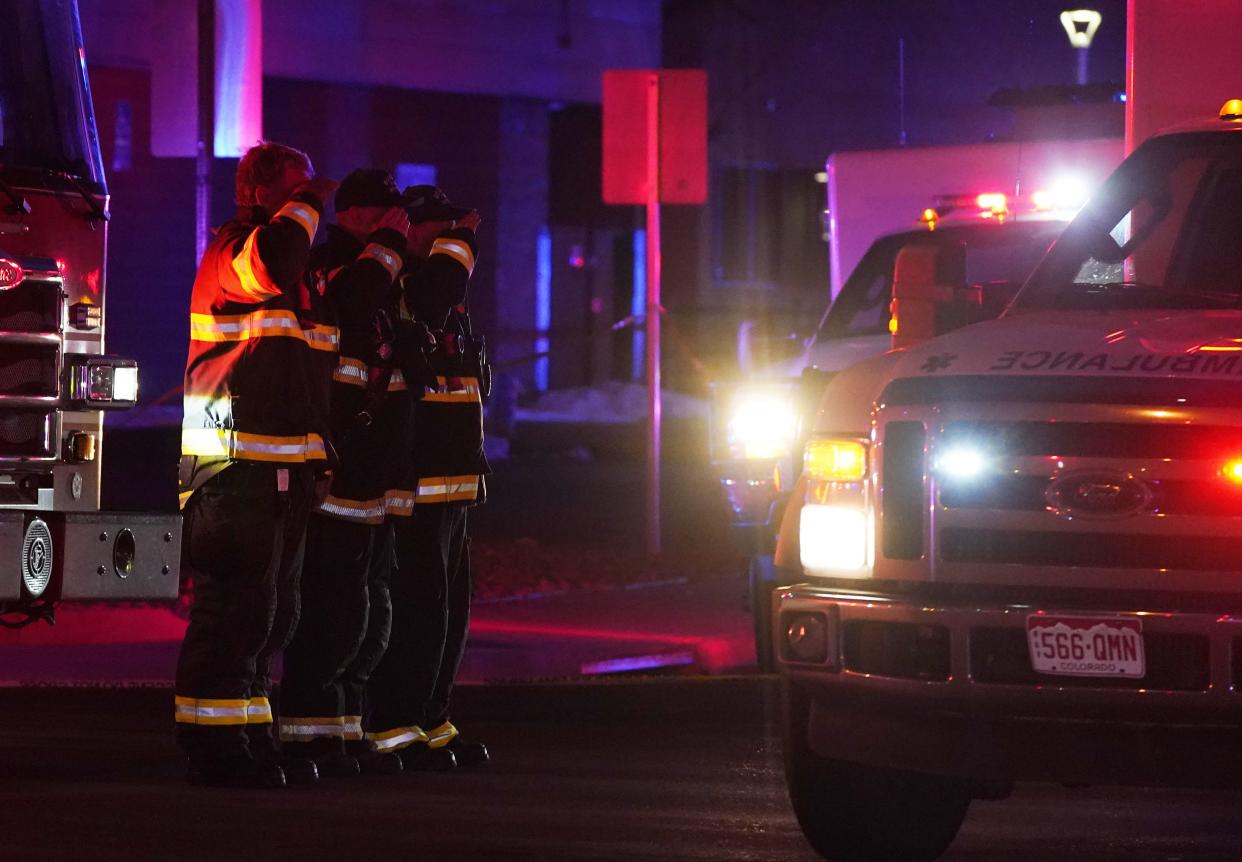 Firefighters salute an ambulance as it leaves a King Soopers grocery store where authorities say multiple people have been killed in a shooting, Monday, March 22, 2021, in Boulder, Colo.