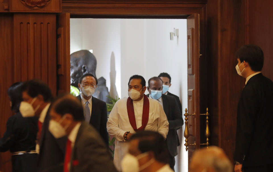 Yang Jiechi, Director of the Central Foreign Affairs Commission of the Chinese Communist Party, center left, and Sri Lankan Prime Minister Mahinda Rajapaksa, center right, arrive for a meeting in Colombo, Sri Lanka, Friday, Oct. 9, 2020. A high level Chinese delegation led by Yang Jiechi met Sri Lankan leaders including president Gotabaya Rajapksa to discuss strengthening of economic ties between the two countries. (AP Photo/Eranga Jayawardena)