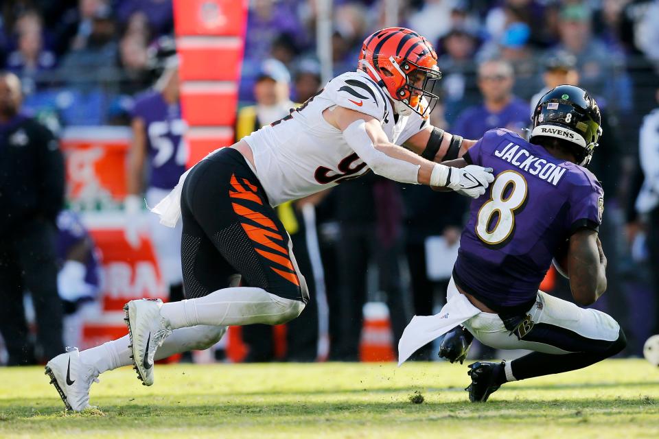 Baltimore Ravens quarterback Lamar Jackson (8) is brought down by Cincinnati Bengals defensive end Sam Hubbard (94) in the third quarter of the NFL Week 7 game between the Baltimore Ravens and the Cincinnati Bengals at M&T Bank Stadium in Baltimore on Sunday, Oct. 24, 2021. The Bengals moved into the top of the AFC North with a 41-17 win over the Ravens. 