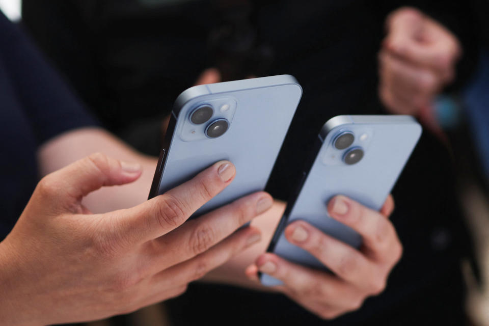 A guest holds the new iPhone 14 at an Apple event at their headquarters in Cupertino, California, U.S. September 7, 2022. REUTERS/Carlos Barria