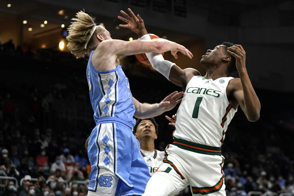 North Carolina forward Brady Manek, left, and Miami forward Anthony Walker (1) go for a rebound during the first half of an NCAA college basketball game, Tuesday, Jan. 18, 2022, in Coral Gables, Fla. (AP Photo/Lynne Sladky)