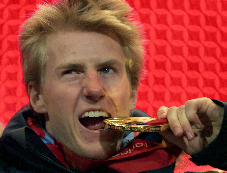 FILE - United States gold medalist Ted Ligety jokes with his medal during the medal ceremony for the Men's Alpine Combined at the Turin 2006 Winter Olympic Games in Turin, Italy Wednesday Feb. 15, 2006. Mikaela Shiffrin's record 83rd World Cup victory Tuesday, Jan. 24, 2023 is only the latest exploit by an American team that has been producing success after success on the circuit since Daron Rahlves and Bode Miller started it all off more than 20 years ago. (AP Photo/Greg Baker, File)