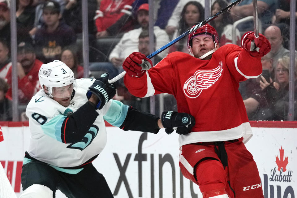 Seattle Kraken defenseman Brian Dumoulin (8) and Detroit Red Wings right wing Daniel Sprong (88) battle for position in the second period of an NHL hockey game Tuesday, Oct. 24, 2023, in Detroit. (AP Photo/Paul Sancya)