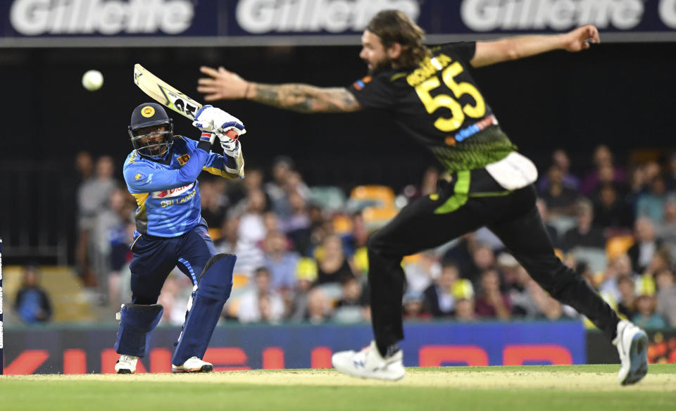 Sri Lanka's Lakshan Sandakan, left, hits four runs past Australia's Kane Richardson during their T20 cricket match in Brisbane, Wednesday, Oct. 30, 2019. (Darren England/AAP Image via AP)