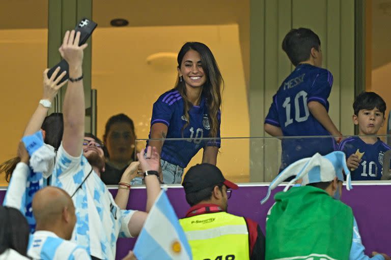 The wife of Argentina's forward Lionel Messi, Antonela Roccuzzo, greets supporters ahead of the Qatar 2022 World Cup football semi-final match between Argentina and Croatia at Lusail Stadium in Lusail, north of Doha on December 13, 2022. (Photo by JUAN MABROMATA / AFP)