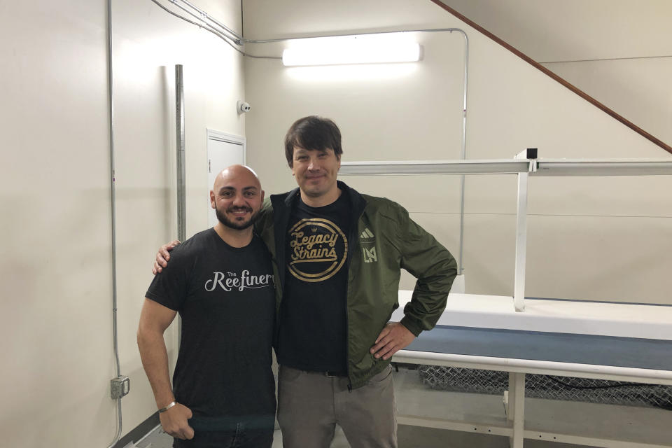 Cannabis cultivator Erik Hultstrom, right, stands with his friend and dispensary owner Gregory Meguerian on March 24, 2023, in a mostly vacant Los Angeles warehouse he once used. Along the West Coast, which has dominated U.S. marijuana production from long before legalization, producers are struggling with what many call the failed economics of legal pot...a challenge inherent in regulating a product that remains illegal under federal law. Hultstrom, who envisioned thriving in a green rush economy, five years later sold his license and is trying to figure out how to contract with a large grower. (AP Photo/Mike Blood)