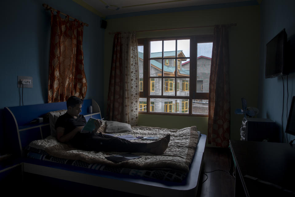Humzah Mir studies inside his bedroom in Srinagar, Indian controlled Kashmir, Friday, July 17, 2020. Schools in the disputed region reopened after six months in late February, after a strict lockdown that began in August 2019, when India scrapped the region’s semi-autonomous status. In March schools were shut again because of the coronavirus pandemic. Humzah, who cleared his grade X exams a few days ago, says it will be a hard road ahead with no proper classes. (AP Photo/Dar Yasin)