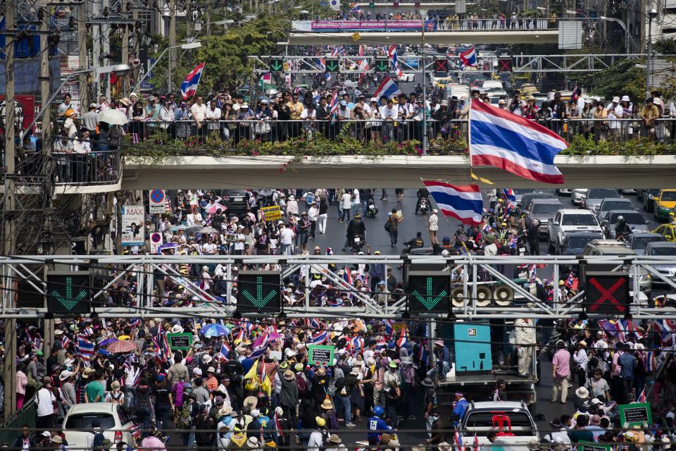 Supporters and spectators stand on a pedestrian overpass during an anti-government protest march, Sunday, Jan. 19, 2014, in Bangkok. Two explosions shook an anti-government demonstration site in Thailand's capital on Sunday, wounding at least 28 people in the latest violence to hit Bangkok as the nation's increasingly volatile political crisis drags on. (AP Photo/John Minchillo)