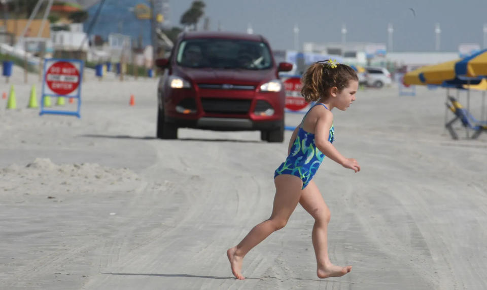 A young beachgoer deals with crossing the traffic lane in front of Splash Park on Daytona Beach Wednesday, April 29, 2015.