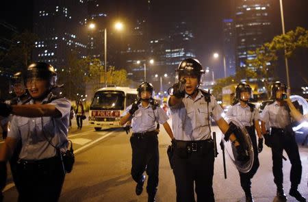 A police officer yells at protesters to move away from the road as they try to block an area near the government headquarters building in Hong Kong in this October 15, 2014 file photo. REUTERS/Carlos Barria/Files