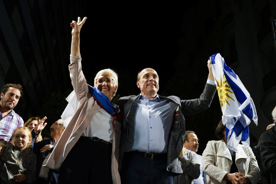 Presidential candidate for the ruling party Broad Front Daniel Martinez, right, and Graciela Villar, his running mate, wave to supporters at their headquarters in Montevideo, Uruguay, Sunday, Nov. 24, 2019. Uruguayans voted Sunday in a run off presidential election between Martinez and Luis Lacalle, from the the opposition National Party. With the runoff election to close to call neither candidate is conceding to the other. (AP Photo/Matilde Campodonico)