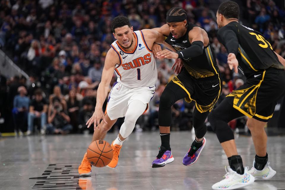 Phoenix Suns guard Devin Booker (1) dribbles past Golden State Warriors guard Moses Moody (4) in the third quarter at the Chase Center in San Francisco on March 13, 2023.