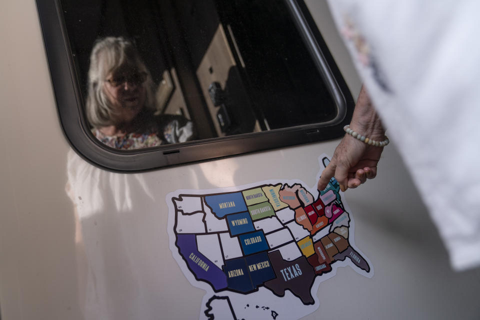 Sandy Phillips is reflected in her RV window as she looks at the states she and her husband, Lonnie, traveled to while visiting mass shootings across the country, as the RV sits in a storage lot in Longmont, Colo., Monday, Sept. 4, 2023. Phillips didn’t consider it radical to believe weapons of war had no place on American streets. Her parents gave her a gun for her 10th birthday and she enjoyed bird hunting as a girl. She was a Texan, long aligned with Republican politics. Now, she found their intransigence on guns maddening. “Innocent people and children are dying,” she said, “and people go, ‘Oh well, nothing we can do.’” (AP Photo/David Goldman)