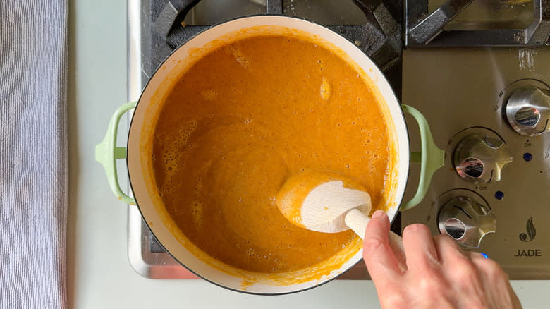 Peach bbq sauce simmering in a pot on stovetop