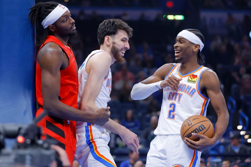 Oklahoma City Thunder forward Chet Holmgren (7) and guard Shai Gilgeous-Alexander (2) celebrate beside Portland Trail Blazers forward Jerami Grant (9) after Holmgren made a basket and was fouled during an NBA basketball game between the Oklahoma City Thunder and the Portland Trail Blazers at Paycom Center in Oklahoma City, Thursday, Jan. 11, 2024.