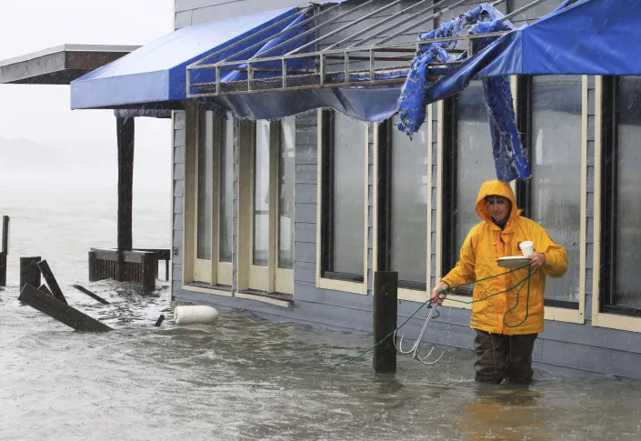 FILE - A worker retrieves a grappling hook on the dock next to Bubba's restaurant on the water in Virginia Beach, Va., Monday, Oct. 29, 2012. Voters in Virginia Beach will consider whether to vote for a $500 million bond on election day that would be used for protection against flooding from rising seas and intensifying hurricanes.(AP Photo/Steve Helber)