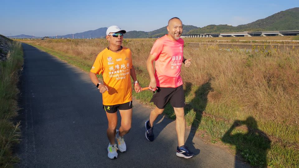 Leung jogs alongside a guide during his recent long-distance run in Japan. - The Roly-Poly Inclusion Movement Association