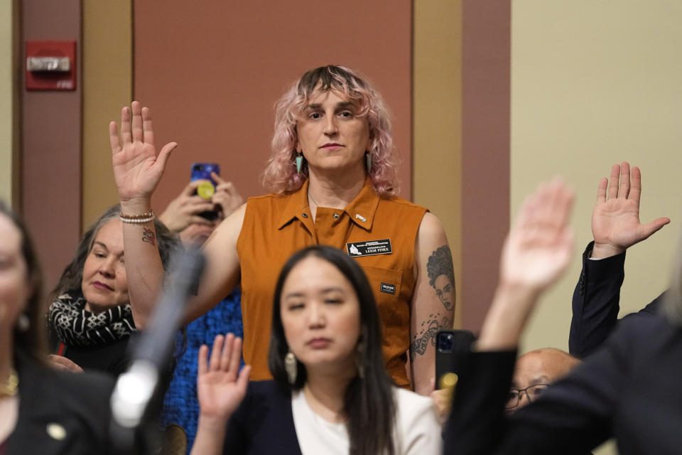 Leigh Finke, center, the first transgender person elected to the state's legislature, is sworn in to the Minnesota House of Representatives during the first day of the 2023 legislative session, Tuesday, Jan. 3, 2023, in St. Paul, Minn. (AP Photo/Abbie Parr)