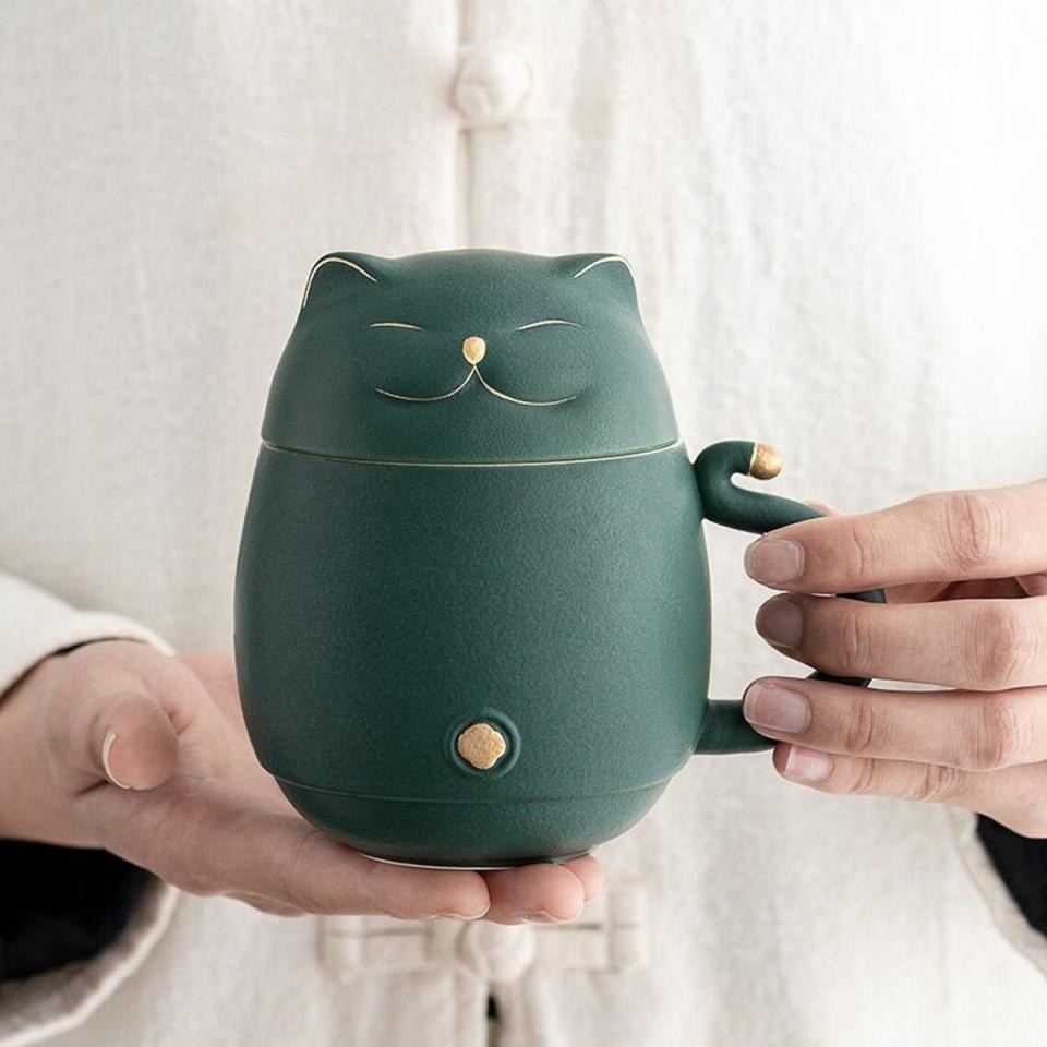 Photo of someone holding a Lucky Cat Ceramic Tea Cup with Infuser