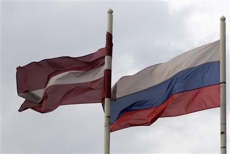 A Latvian (L) flag flutters in the wind next to a Russian flag near a hotel in Daugavpils March 21, 2014. REUTERS/Ints Kalnins