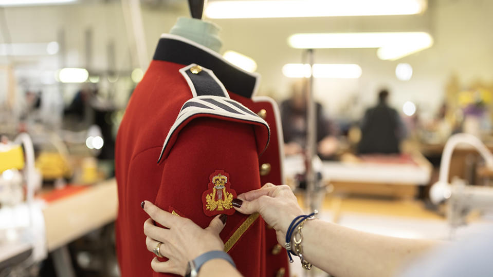 LONDON, ENGLAND - APRIL 11: A Lyre badge with the new Tudor Crown also known as the Imperial Crown is placed onto a scarlet tunic ahead of the Kings Coronation at Kashket & Partners on April 11, 2023 in London, England. Kashket & Partners are a leading specialist for the design, development, and manufacture of uniforms for ceremonial, parade and formal wear in the UK and overseas. Their work can be seen in the scarlet tunics of the guards outside Buckingham Palace to the dress and undress uniform of the Yeomen Warders at the Tower of London. Since the beginning of the new year, work has been underway to create and roll out the new insignia, CR III, that will eventually adorn the uniforms of members of the Armed Forces, Beefeaters at the Tower of London, Police forces across the UK, British government buildings, state documents and mailboxes. Kashket has enjoyed a close relationship with royalty for many years, from the days when Alfred Kashket, the company’s founder, made felt hats for Tsar Nicholas II. The company also made the wedding uniforms of both Prince William, the Duke of Cambridge and Prince Harry, the Duke of Sussex. The company has made ceremonial wear for royalty all over the world, including eight kings, as well as the British Royal Family from whom Firmin & Sons, a sister company based in Birmingham, have the honour of a Royal Warrant, first given in 1837. Royal warrants of appointment have been issued for centuries to tradespeople who supply goods or services to a royal court. The process of changing everything from E II R, Queen Elizabeth ‘regina,’ which means queen in latin to CR III, King Charles ‘Rex,’ the latin word for king, has been years in the planning, and will take many more years to complete with around 8000 pieces of dress already changed ahead of the King's Coronation on May 6. (Photo by Dan Kitwood/Getty Images)