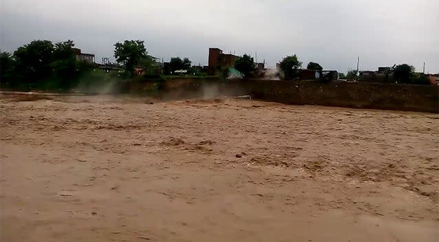 The bridge disappears into the swollen river. Photo: Supplied