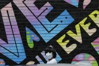 A pedestrian wears a protective mask during the coronavirus pandemic while walking along East 60th Street Friday, May 22, 2020, in New York. (AP Photo/Frank Franklin II)