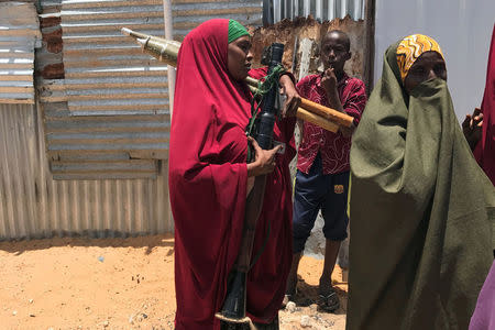 A Somali Armed Forces member carries her ammunition during fighting between the military and police backed by intelligence forces in the Dayniile district of Mogadishu, Somalia September 16, 2017. REUTERS/Feisal Omar