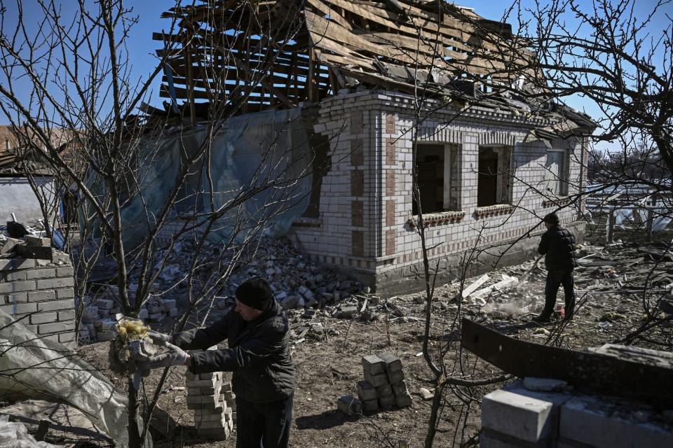 People working around the site of a destroyed house.