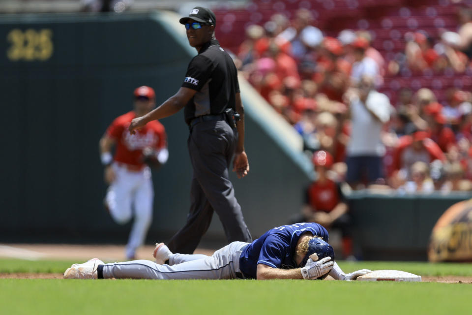 Tampa Bay Rays' Taylor Walls lies on the ground after being thrown out at first base after hitting a single during the third inning of a baseball game against the Cincinnati Reds in Cincinnati, Sunday, July 10, 2022. (AP Photo/Aaron Doster)