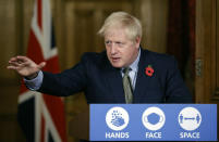 FILE - In this Nov. 9, 2020 file photo Britain's Prime Minister Boris Johnson reaches out during a virtual press conference on the coronavirus pandemic at 10 Downing Street in central London. Johnson is self-isolating after being told he came into contact with someone who tested positive for the coronavirus, officials said Sunday Nov. 15. "He will carry on working from Downing Street, including on leading the government's response to the coronavirus pandemic," a statement from his office said. (Tolga Akmen / Pool via AP, File)