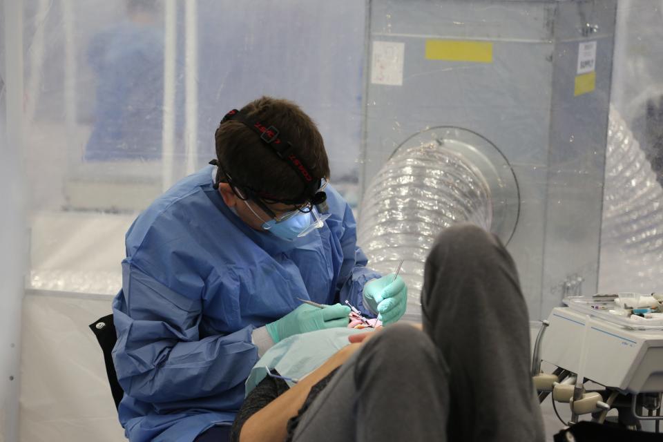 A volunteer dental professional does a dental procedure on a patient at a Remote Area Medical's past clinic.