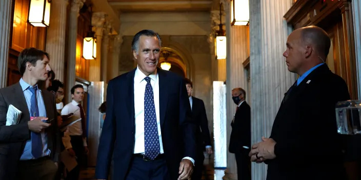 Mitt Romney walking by reporters in Senate hall