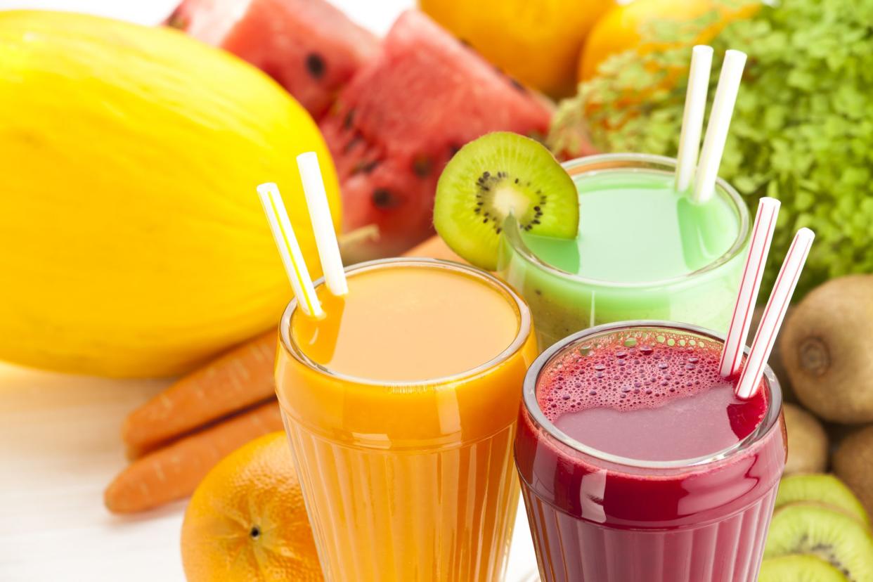 Close Up of Three Glasses of Fruit Juices on White Garden Table. High Angle View.