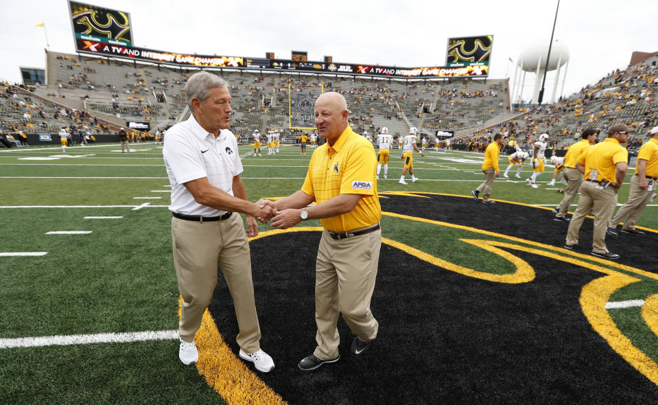 Iowa head coach Kirk Ferentz (L) talks with Wyoming head coach Craig Bohl. (AP)