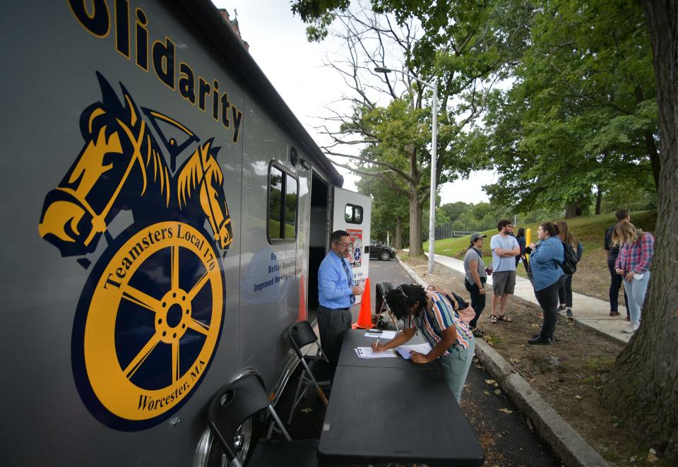 Johnny Davila signs in for a ballot as the line forms. Clark University Graduate Workers Union members were voting on whether to authorize a strike Monday afternoon. They voted in a trailer provided by the Teamsters.