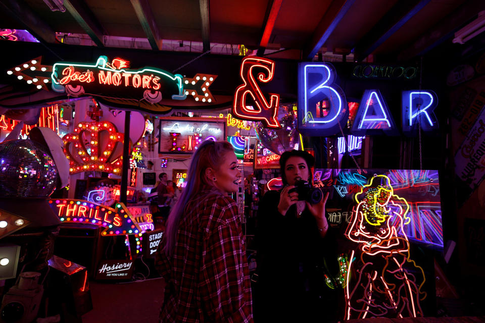 People take pictures of neon signs