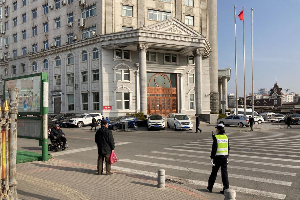 A police officer stands outside a court building in Dandong in northeastern China's Liaoning Province, Friday, March 19, 2021. China was expected to open the first trial Friday for Michael Spavor, one of two Canadians who have been held for more than two years in apparent retaliation for Canada's arrest of a senior Chinese telecom executive. (AP Photo/Ken Moritsugu)