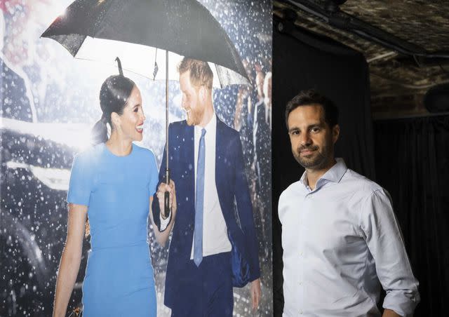 <p>John Nguyen/PA Media Assignments</p> Samir Hussein with his photo of Prince Harry and Meghan at the launch of Princess Diana: Accredited Access Exhibition in London on May 23, 2024