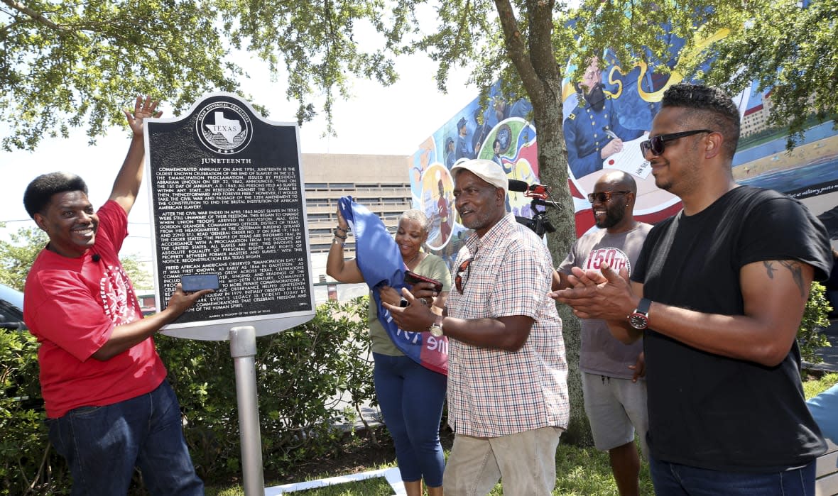 Sam Collins III, left, and others celebrate at the Juneteenth historical marker on June 17, 2021, in Galveston, Texas, after President Joe Biden signed the Juneteenth National Independence Day Act into law. (Jennifer Reynolds/The Galveston County Daily News via AP, File)