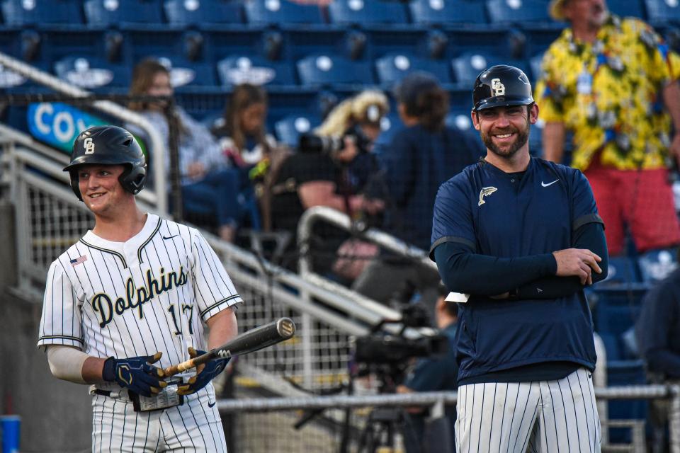 Gulf Breeze head coach Travis Mattair, a former Blue Wahoos player, shares a laugh with outfielder Andrew Thorn in Monday's game against Escambia at Blue Wahoos Stadium.