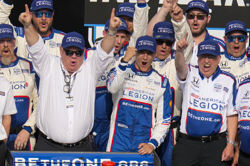 Alex Palou, center, of Spain, celebrates with car owner Chip Ganassi, left, after winning the IndyCar auto race at Indianapolis Motor Speedway in Indianapolis, Saturday, May 13, 2023. (AP Photo/Michael Conroy)