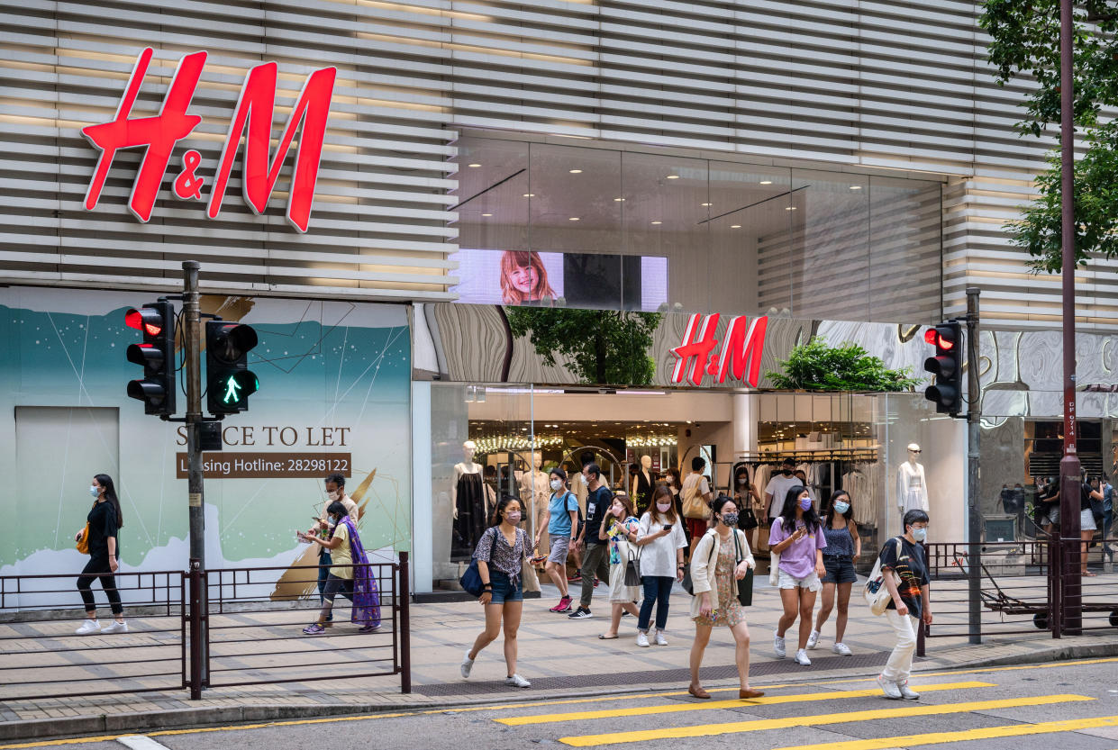 HONG KONG, CHINA - 2021/08/07: Pedestrians cross the street in front of the Swedish multinational clothing design retail company Hennes & Mauritz, H&M, store in Hong Kong. (Photo by Budrul Chukrut/SOPA Images/LightRocket via Getty Images)