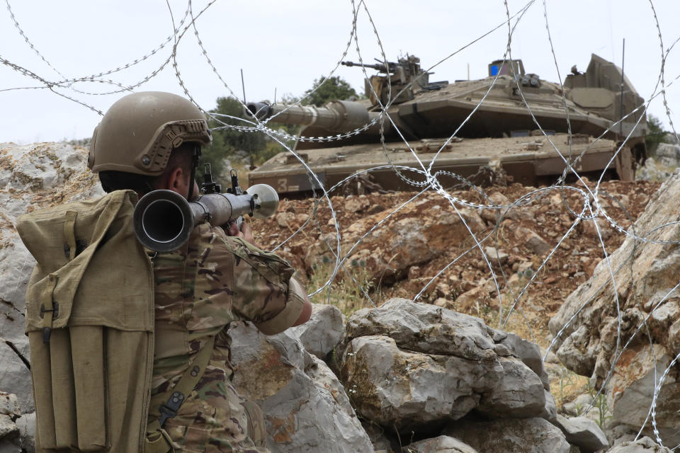 A Lebanese soldier points his rocket-propelled-grenade toward an Israeli Merkava tank in the disputed Kfar Chouba hills along the border, south Lebanon, Friday, June 9, 2023. Israeli soldiers fired tear gas to disperse scores of protesters who pelted the troops with stones along the border with Lebanon Friday, leaving some Lebanese demonstrators and troops suffering breathing problems. (AP Photo/Mohammad Zaatari)