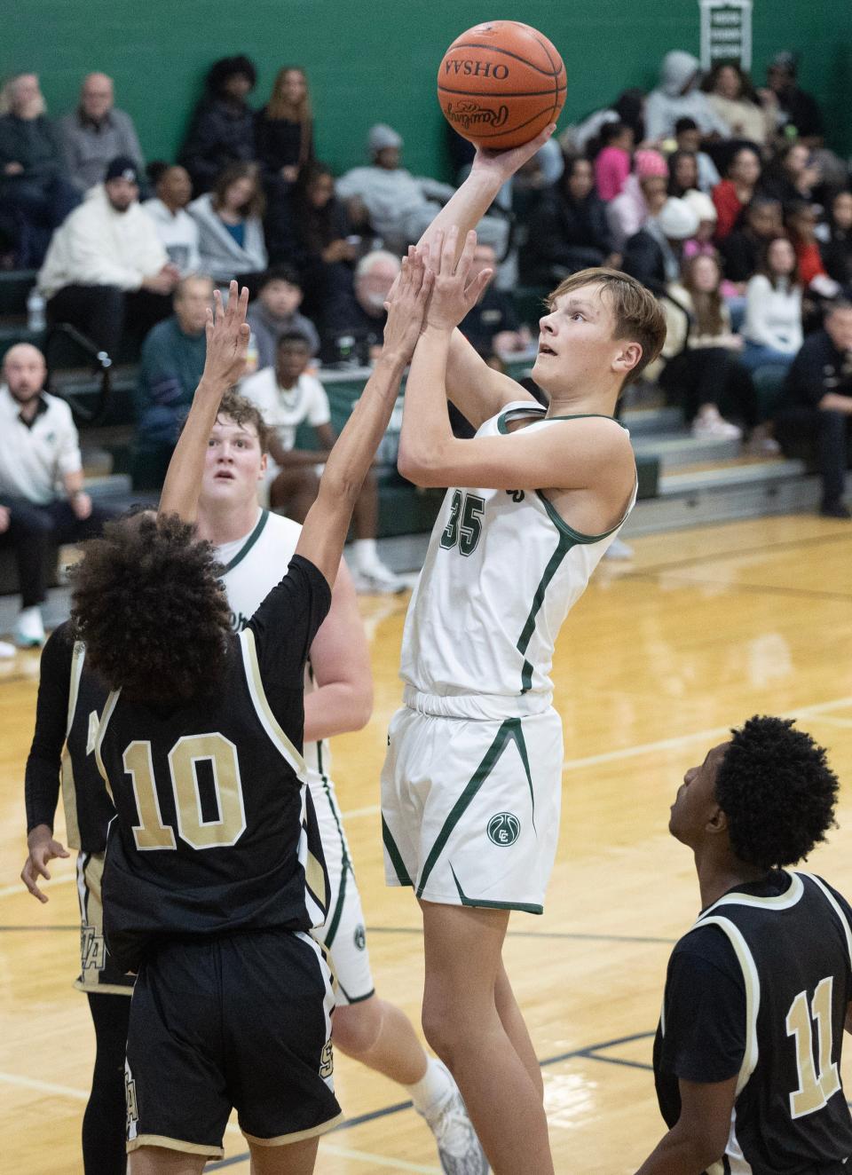 Central Catholic's William Minor shoots over St. Thomas Aquinas defender Dre Barnes in the second half of Friday's game.