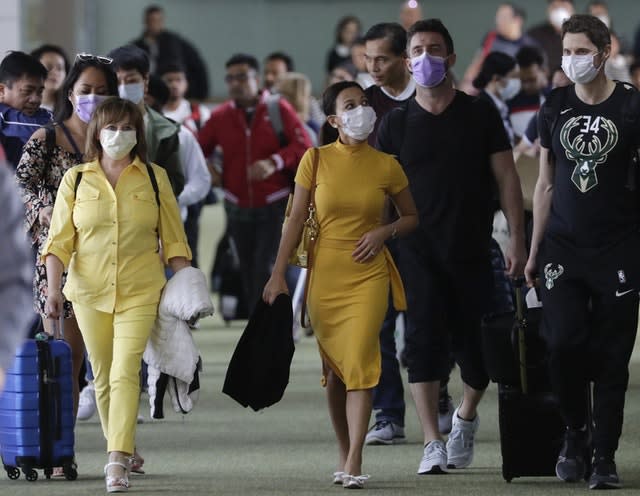 Passengers wear masks as they arrive at Manila’s international airport 