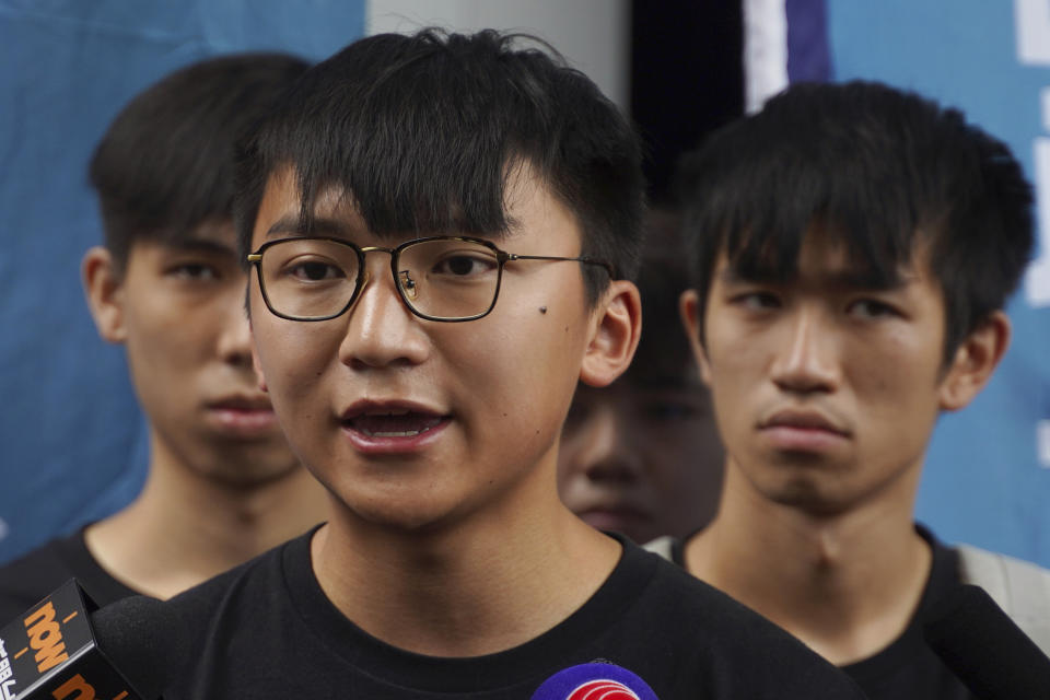 Issac Cheng, vice-chairperson of Demosisto, center, speaks to reporters in Hong Kong Friday, Aug. 30, 2019. Demosisto, a pro-democracy group in Hong Kong, posted on its social media accounts that well-known activist Wong had been pushed into a private car around 7:30 a.m. Friday, Aug. 30, 2019 and was taken to police headquarters. It later said another member, Agnes Chow, had also been arrested, at her home. (AP Photo/Vincent Yu)