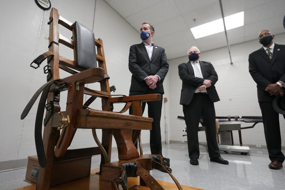 FILE - Virginia Gov. Ralph Northam, left, looks over the electric chair in the death chamber at Greensville Correctional Center in Jarratt, Va., with Operations Director George Hinkle, center, and Director of the Department of Corrections Harold Clarke, right, prior to signing a bill abolishing the state's death penalty, March 24, 2021. The Virginia Department of Corrections has recorded audio of at least 30 executions over the last three decades, but it has no plans to release the tapes publicly. The department rejected an Associated Press request under the state's public records law to release the recordings after NPR obtained and reported on four of them. (AP Photo/Steve Helber, File)