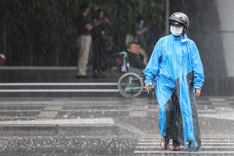 12縣市大雨特報（2） 中央氣象署9日表示，午後對流旺盛，針對12縣市發 布大雨特報。圖為新北市下起大雨，民眾穿上雨衣過 馬路。 中央社記者鄭清元攝  113年6月9日 